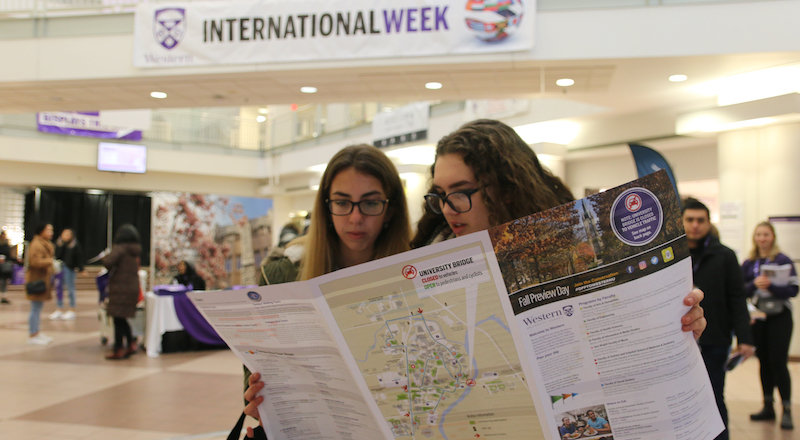 Two prospective students of Western University check out a map for the latest events during International Week