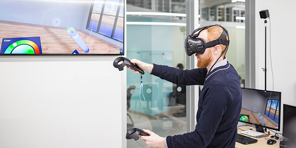 A student wearing virtual reality gear controls a screen with his movements.