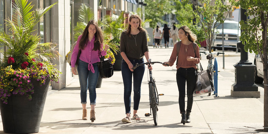 Three students enjoy a sunny walk downtown.