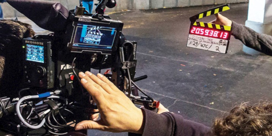 Close up of a camera crew shooting a digital slate for a film.