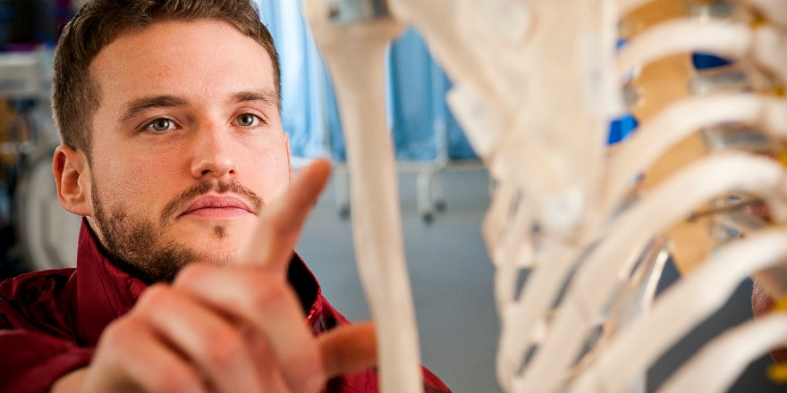 A Middlesex University student builds his knowledge of anatomy by working with a model of a human skeleton.