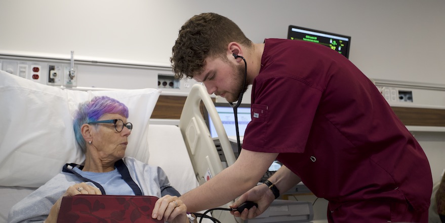 A student at Western University takes advantage of a unique experiential learning opportunity by working in healthcare with an elderly patient.